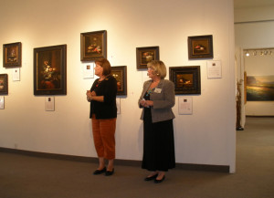 Margret short in front of her paintings at art gallery