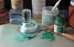 photograph of green paint with pallet knife and painting supplies