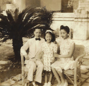 vintage black and white photograph of A Portrait of Mok Lan with her mother and father