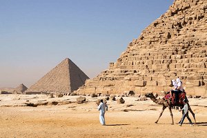 Egyptian pyramids with man riding camel in foreground